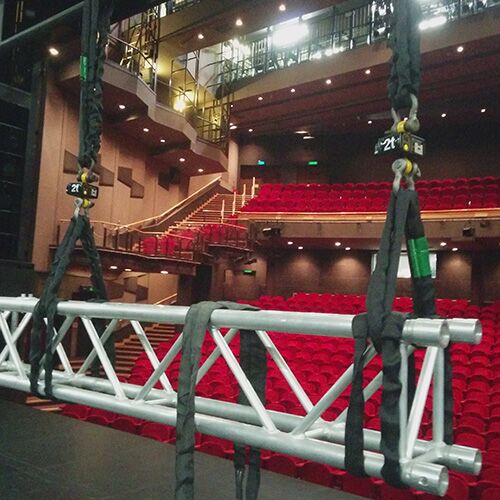 A truss hangs suspended above a stage with two load cells